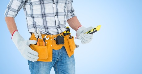 Handy man standing with tools against blue background