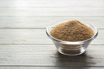 Glass bowl of bread crumbs on white wooden table