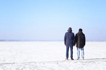 Happy gay couple holding hands together, outdoors