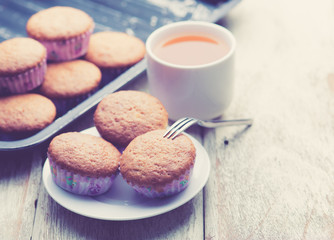 banana muffins cake with tea cup on wood background,vintage tone style