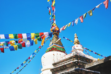 White tibetan stupa with prayer flags