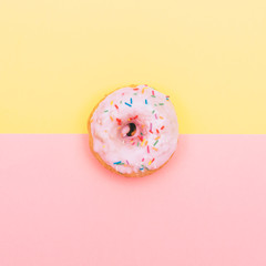 tasty donut with topping on pastel pink and yellow background.
