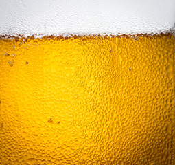 background beer and bubbles with condensation droplets on the outside of the glass