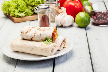 Mexican burritos wraps with mincemeat, beans and vegetables