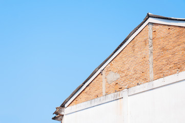 Fototapeta na wymiar Vintage eaves brick wall in blue sky background ,Minimal old geometrical building architecture