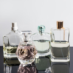 Different perfume bottles with reflections. Perfumery, cosmetics.