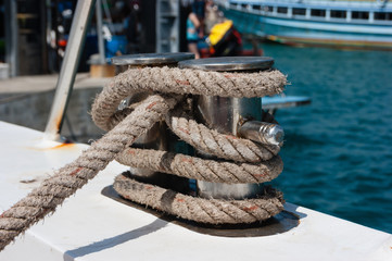Knot on a bollard of a boat. Blue sea in a background.