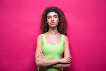 portrait of confident sporty woman in fitness clothing on pink