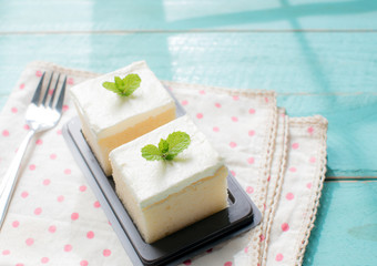 Milk cake delicious on the wood table with shadows from a window frame