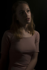 Young girl with pink body isolated on black background 