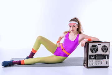 sporty woman lying on training mat near retro record player on white