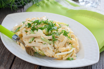 Salad with squid, egg and rice on a white plate, selective focus,horizontal