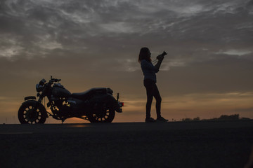 Fototapeta na wymiar biker girl and classic motorcycle at sunse 