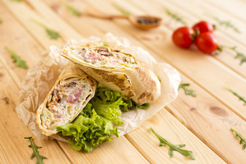 Pepper corn bean quinoa burritos on wood background. Selective focus