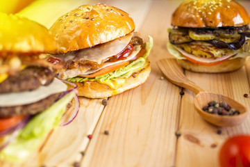 Closeup of fresh homemade burger on an old wooden board with tomato