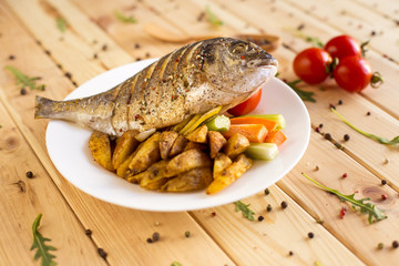 Cooked dorado with potatoes and vegetables