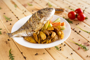 Dorado grilled on a plate served with a slice of lemon