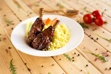 Roasted carrots, potato and cut meat on wood table