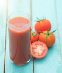 Glass of tomato juice on blue wooden table