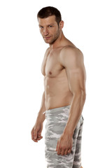 Fototapeta premium half-naked handsome and muscular young man posing on a white background
