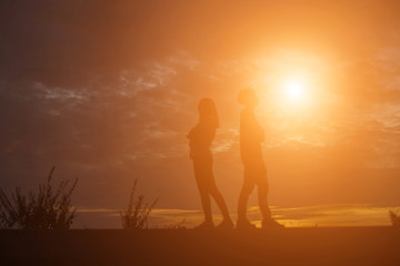 Men and women standing behind on sunset