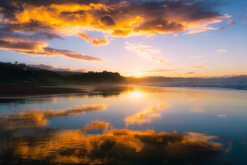 Naklejka na ściany i meble Reflections in Atxabiribil beach at sunset