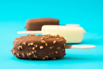 Chocolate ice cream popsicles isolated on blue background. 

