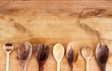 cooking spoons lined up on wooden table