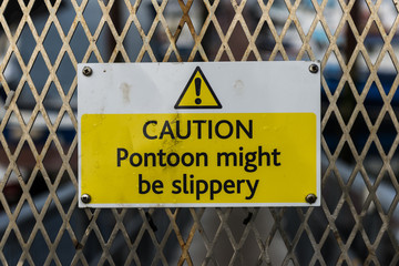 Slippery pontoon bridge warning sign on the harbour entrance