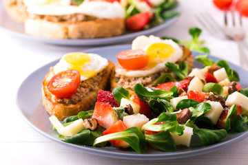 Salad with strawberry, spinach and goat cheese.  Bruschettes