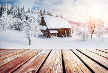 winter mountains landscape with a snowy forest and  wooden hut