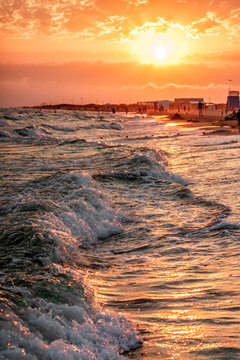 Beautiful scenic landscape of sandy Blaga Beach at stormy Black Sea coast with surfing waves breaking on seashore. Summer sunset seaside vertical scenery. Anapa, Russia