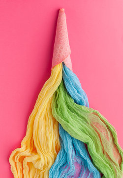 Ice cream cone with colorful streamers  on pink background. Flat lay