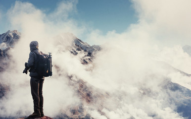 Photographer on cliff. Nature  takes photos with mirror camera  peak of rock.