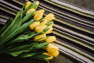 Yellow tulips on a striped mat