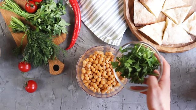 Hummus preparation with chickpeas and parsley and paprika and lemon juice.