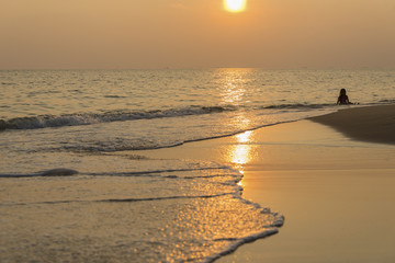 Silhouette kid on the beach at sunset
