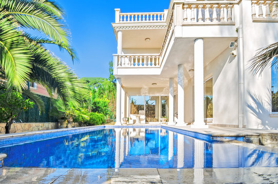 Luxury White House  With Swimming Pool. Luxury Villa In Classical Style With Columns.  Backyard With Swimming Pool In Mansion.