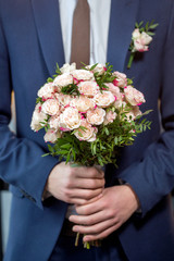 Groom hold wedding bouquet in his hand