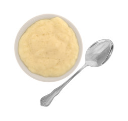 Serving of tapioca pudding in a bowl with a spoon to the side isolated on a white background.