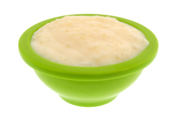 Serving of tapioca pudding in a green bowl isolated on a white background.