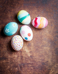 Easter eggs in nest on rustic wooden planks with copyspace. Happy Easter!.