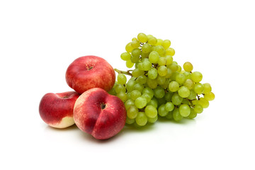 Chinese flat peaches and a bunch of green grapes on white background