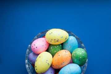 Easter eggs in a crystal dish on a blue background,