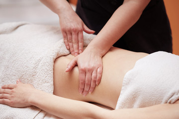 A woman receiving a belly massage at spa salon
