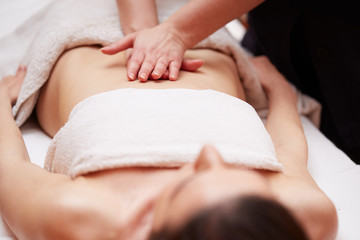 A woman receiving a belly massage at spa salon