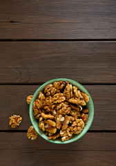 walnuts in a bowl on wooden surface