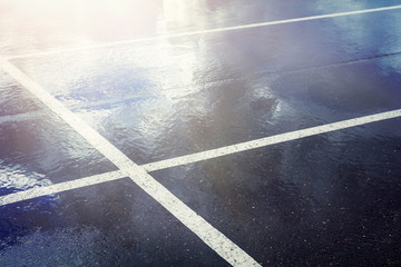 Empty parking lot with stripes . Wet concrete with reflection of blue sky with clouds © Bokehstore