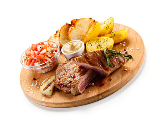 Steaks, baked potatoes and vegetable salad