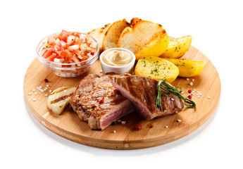 Steaks, baked potatoes and vegetable salad
